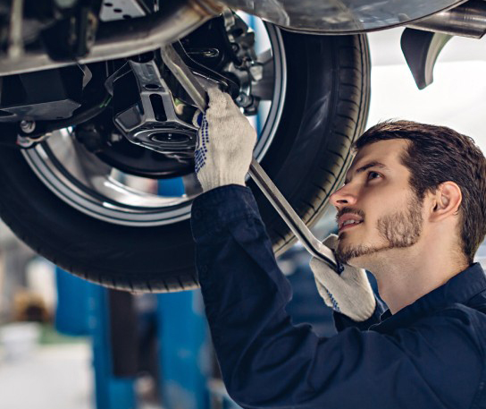 Mechanic at work below vehicle | Davenport Motor Company